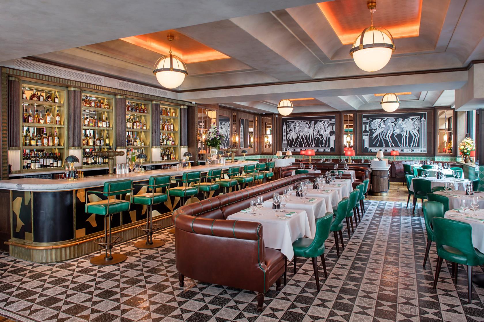 An event space in a restaurant with green leather chairs, white tablecloths, and an art deco bar at Smith & Wollensky.