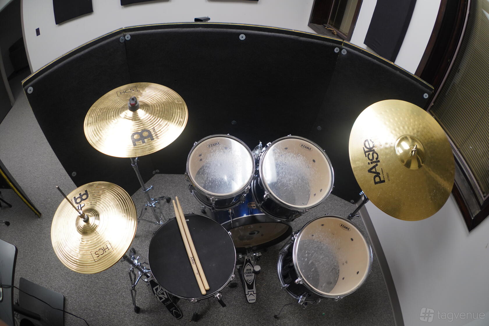 A rehearsal room with a full drum kit setup and soundproof panels at Rehearse Live.