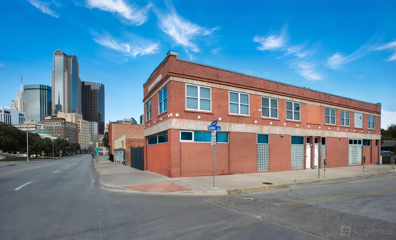A red brick warehouse with large windows and city skyline views at Vacant Gritty Warehouse.