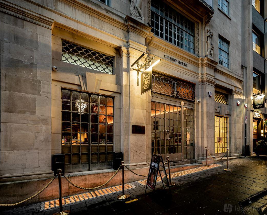 A pub with large grid-style windows and ornate stone facade at The Cocktail Club Bristol Corn Street.