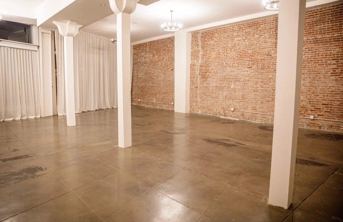 An event space with exposed brick walls, polished concrete floors, and pillar details at Re/creation Center.