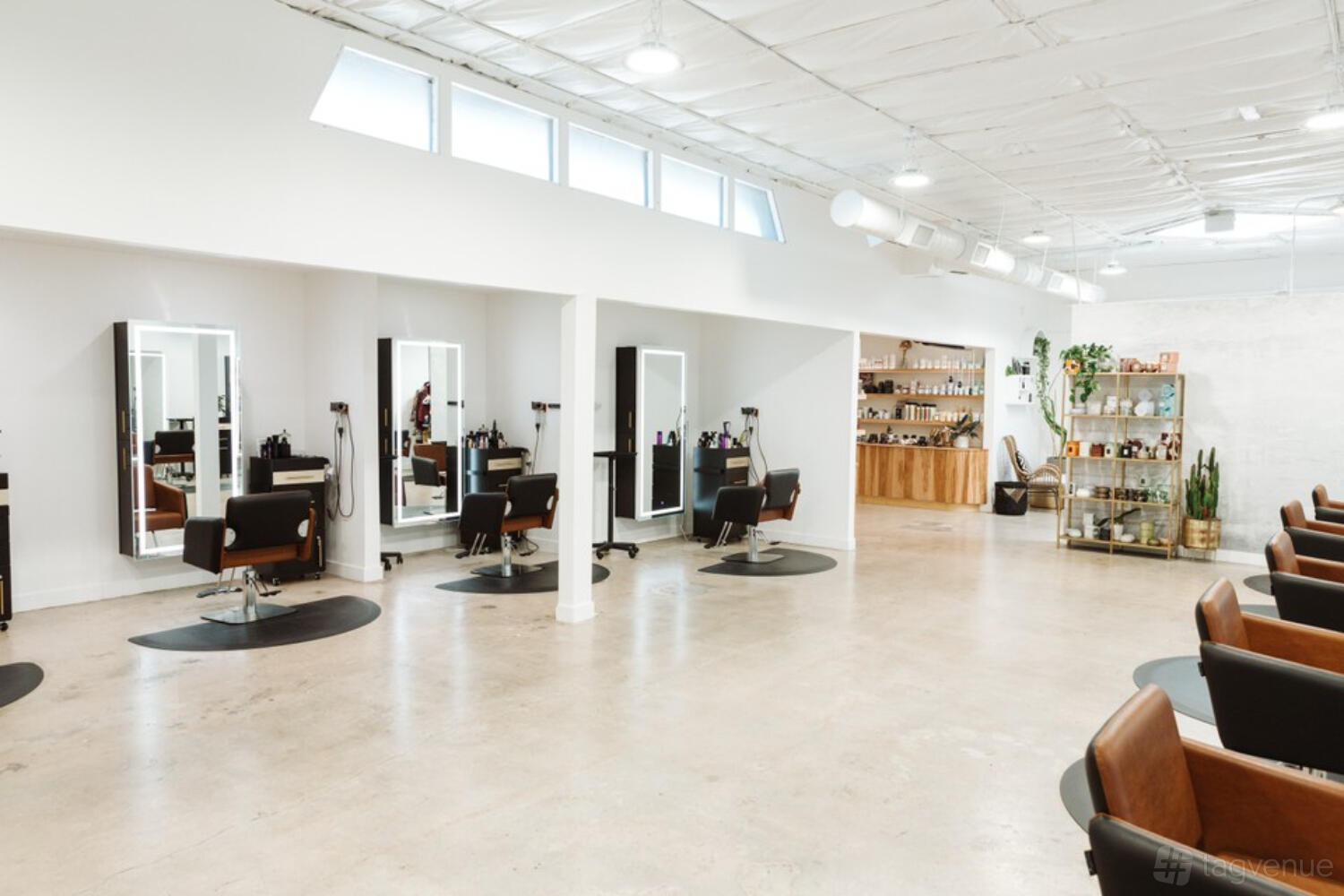 A photo and film studio with salon chairs, large mirrors, and natural lighting at Mane-Tained Salon.