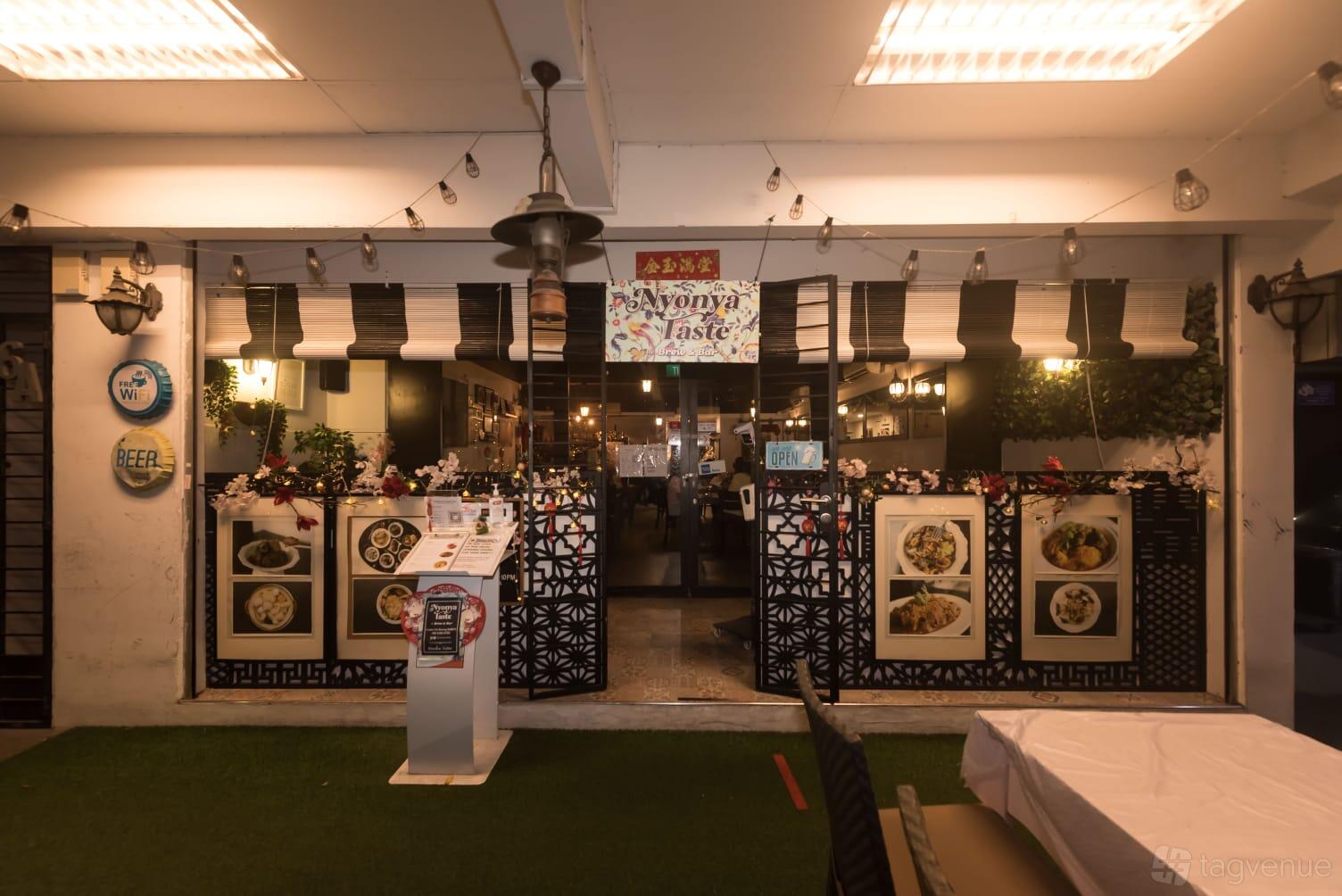 A pub with patterned partition panels, string lights, and menu displays at Nyonya Taste by Brew & Bar.