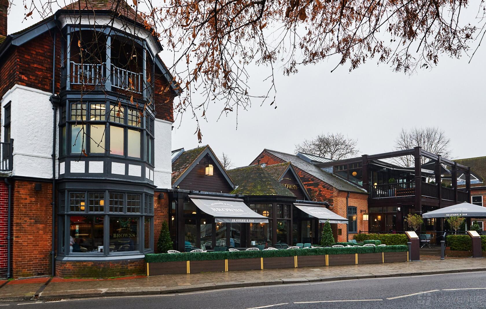A restaurant event space with timber-framed architecture, large windows, and outdoor awnings at Browns Windsor.