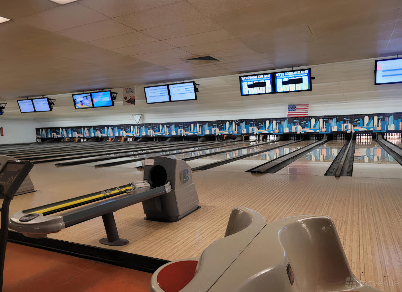 A bowling alley with multiple lanes, digital scoreboards, and colorful wall decor at Skyway Bowl.