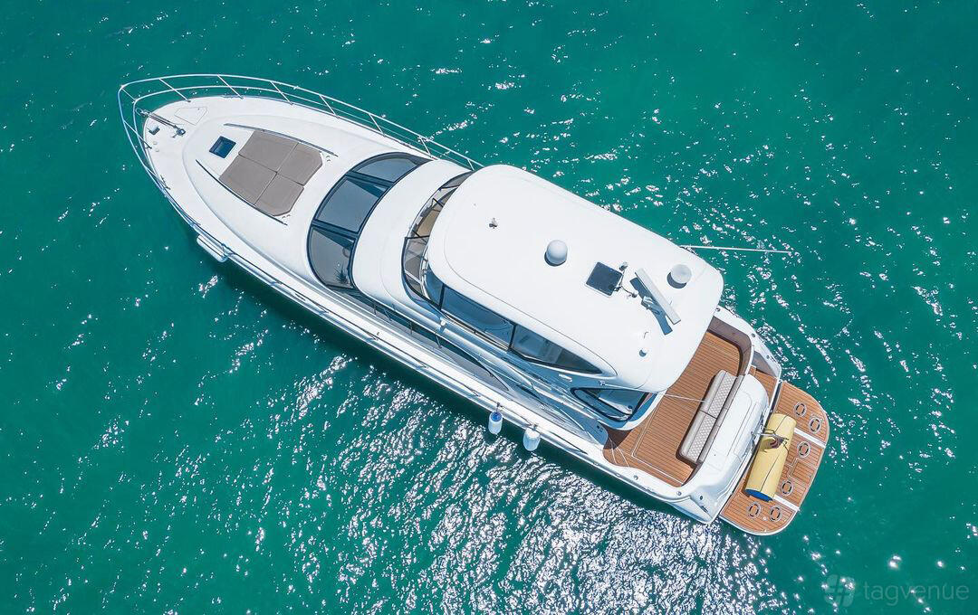 A luxury yacht with a spacious flybridge, sun pads, and teak deck cruising on turquoise water at Jerico Yacht Charters.
