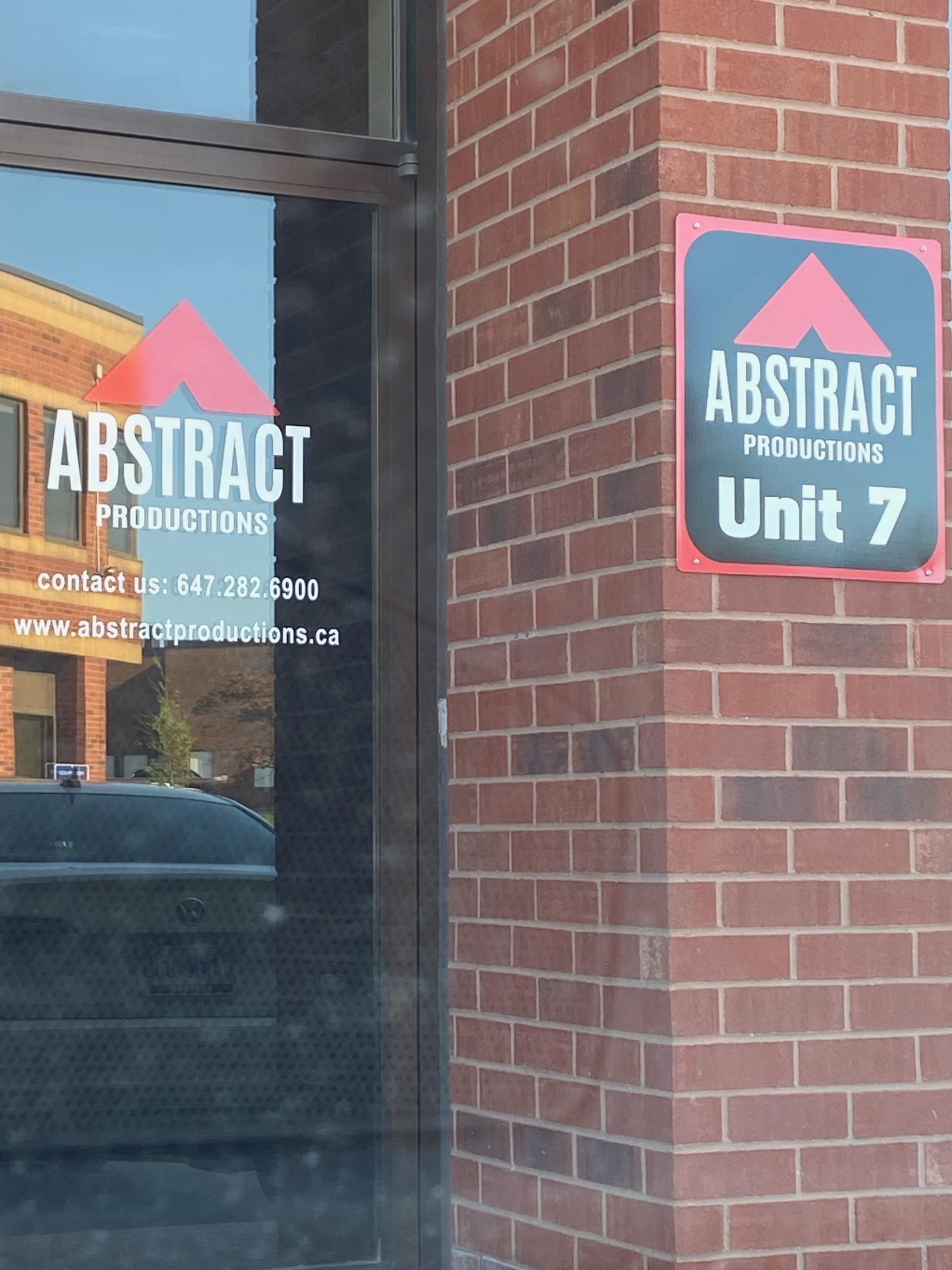 A film and photo studio with a brick exterior and branded glass door at Abstract Productions House.