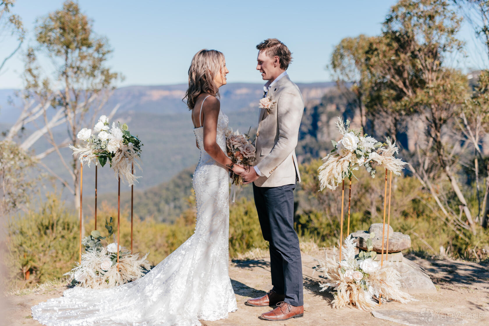 An outdoor wedding venue with floral arrangements and a mountain backdrop at Blue Mountains Weddings.