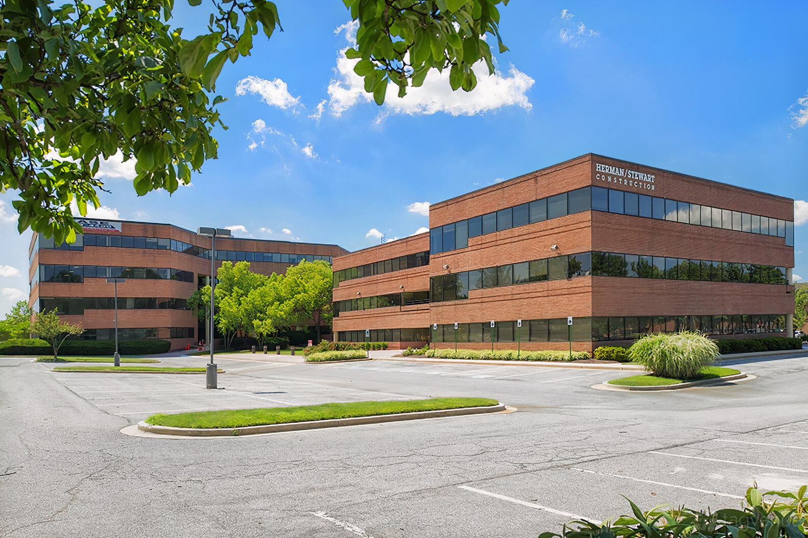 A coworking space in a red brick office building with large tinted windows at Perfect Office Solutions - Lanham 1.