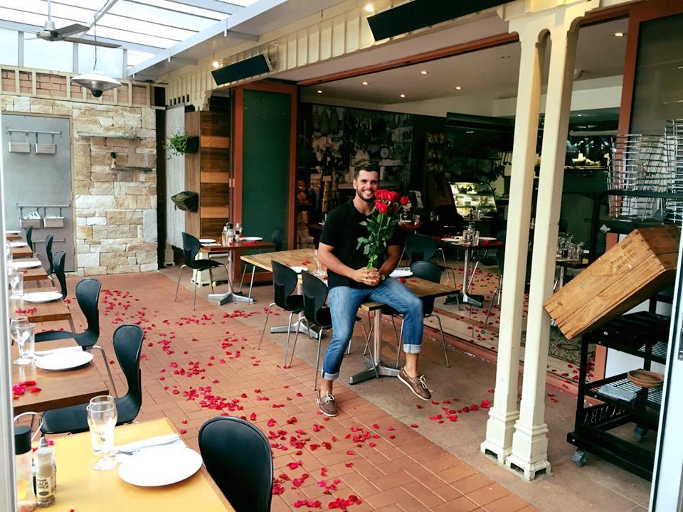 A restaurant with an open-air dining area, scattered rose petals on the floor, and modern tables at Il Posto.