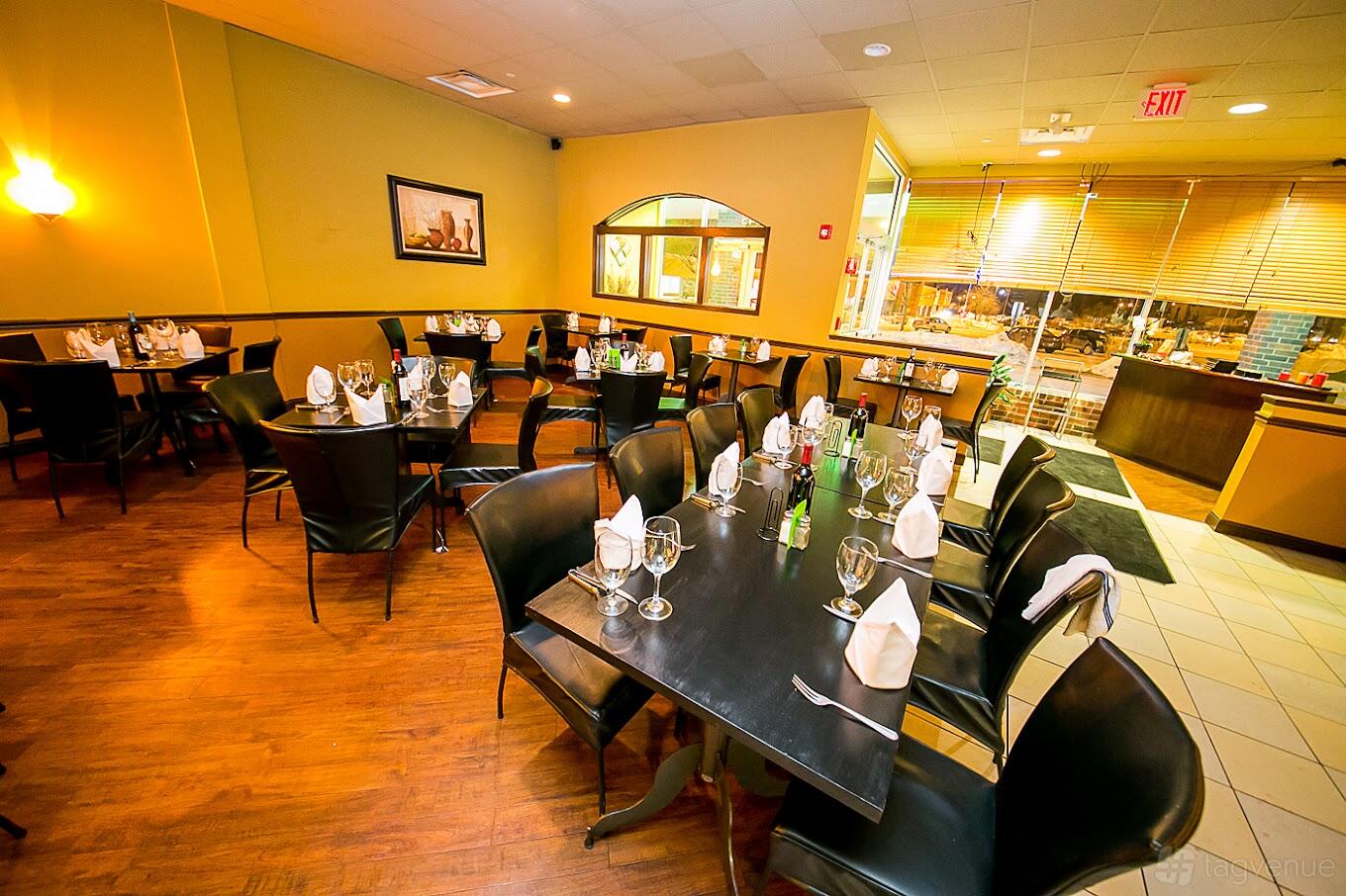 A restaurant dining area with black chairs, set tables with white napkins, and wood floors at Brazil Express Churrasco Grill.