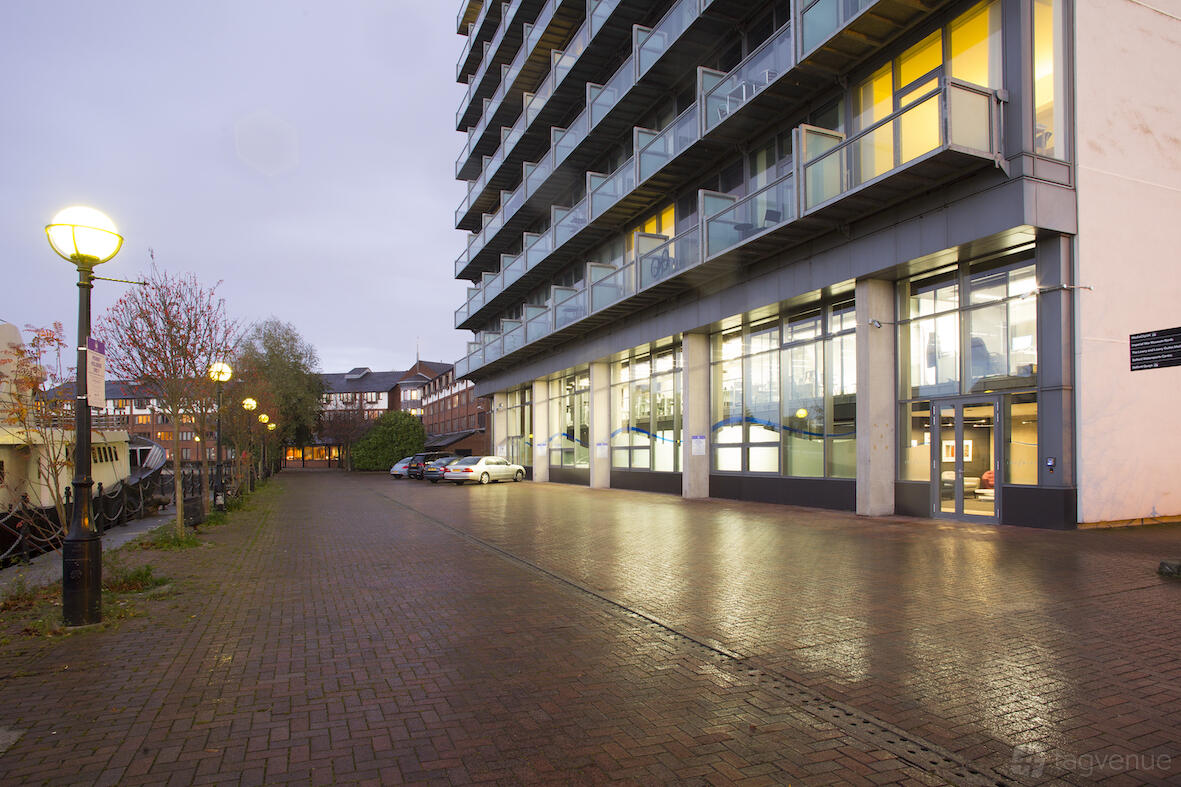 A modern meeting centre with large glass windows and outdoor walkway at The Buzz Rooms.