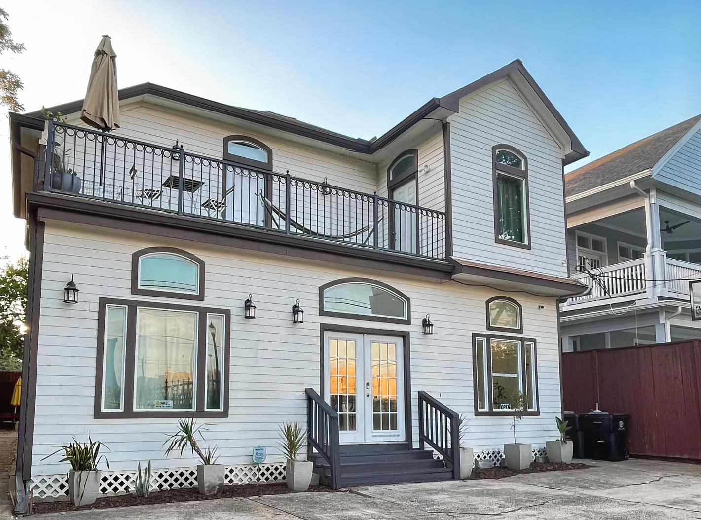 A film and photo studio with a white two-story exterior, balcony, and double glass doors at Wonderlikewander.