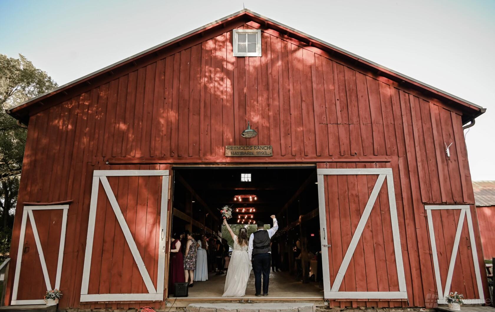 A red barn with open doors and white trim, surrounded by trees at the Western Museum of Mining and Industry.