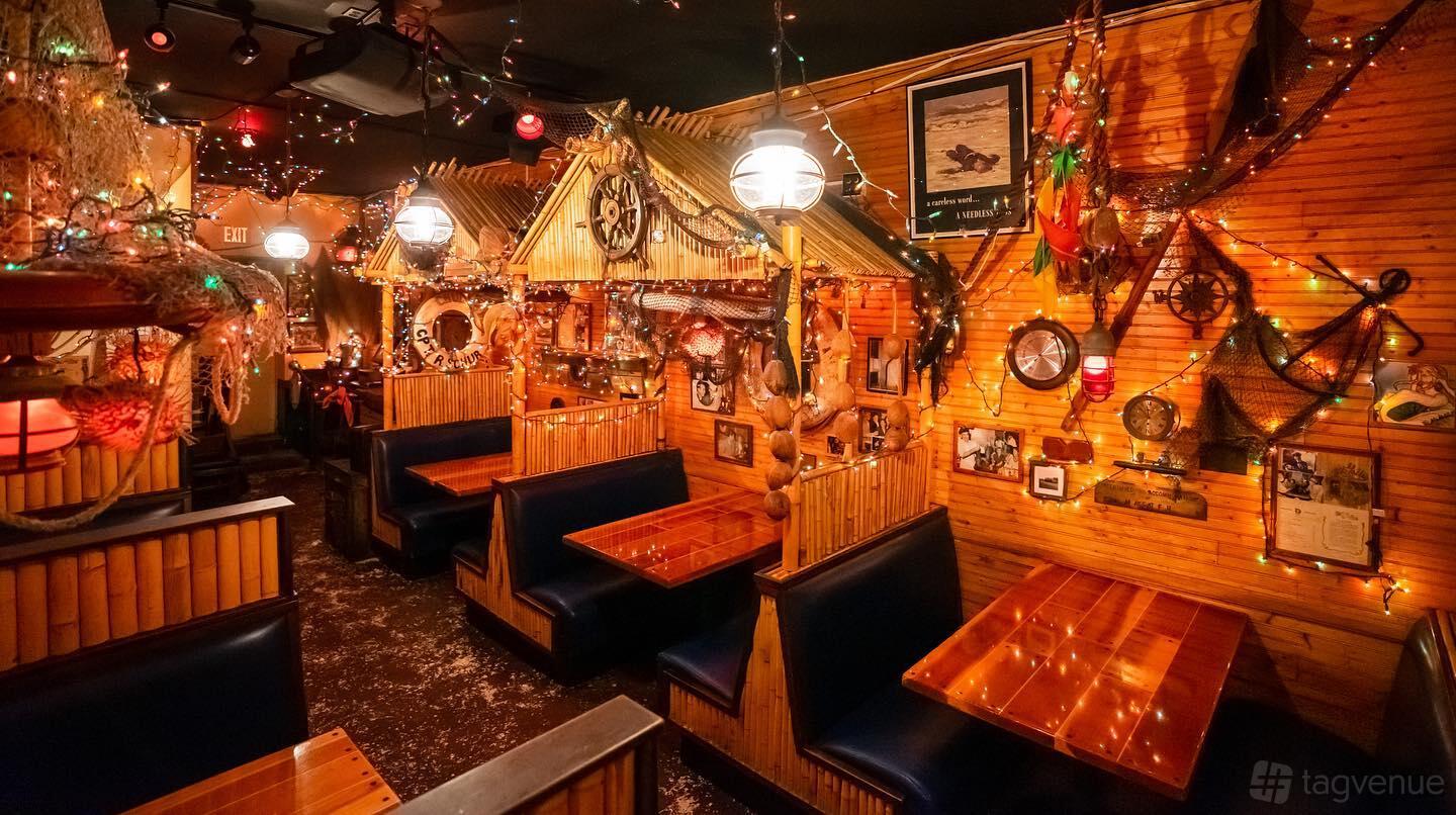 A restaurant with wooden booths, nautical decor, and string lights at The Galley Restaurant.