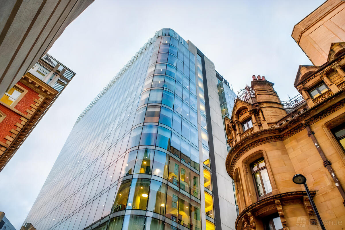 A meeting centre with a glass-fronted high-rise exterior next to historic stone buildings at Landmark: Chancery Place, Manchester.