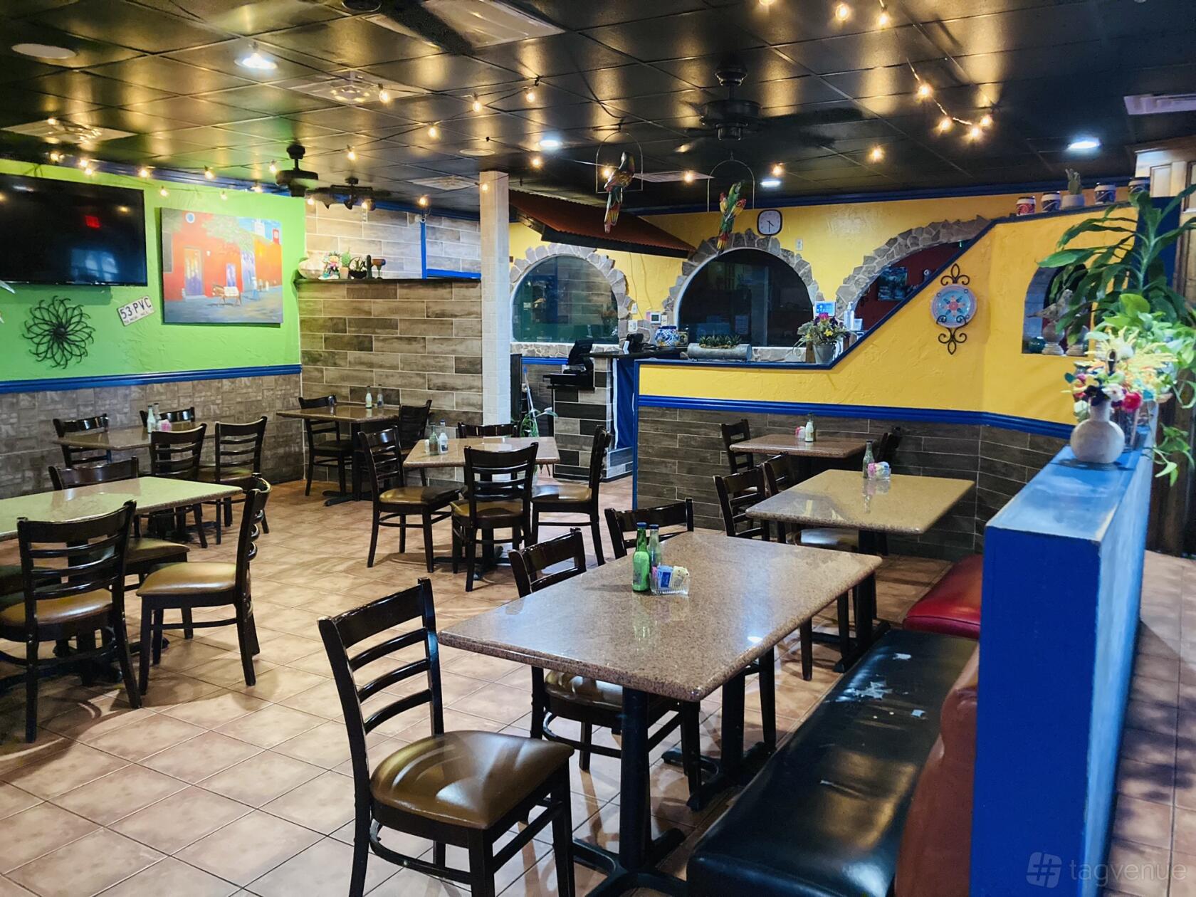An event space in a restaurant with colorful walls, tiled floors, and wooden tables at Las Palomas Mexican Restaurant.