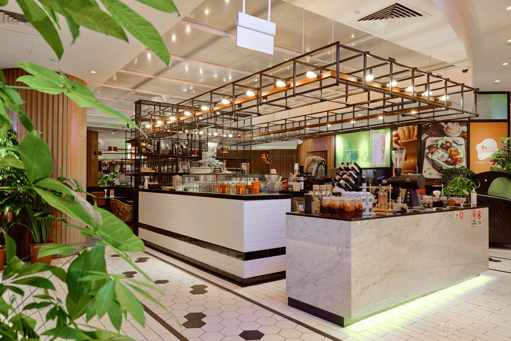 A restaurant with hexagonal tile flooring, marble counters, and greenery at Am I Addicted Korean Pottery Studio.