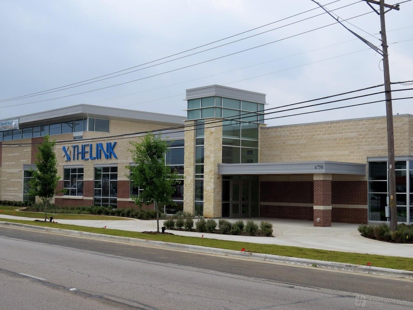 A versatile event space with a modern glass entrance and brick exterior at The Link Event & Recreation Center.