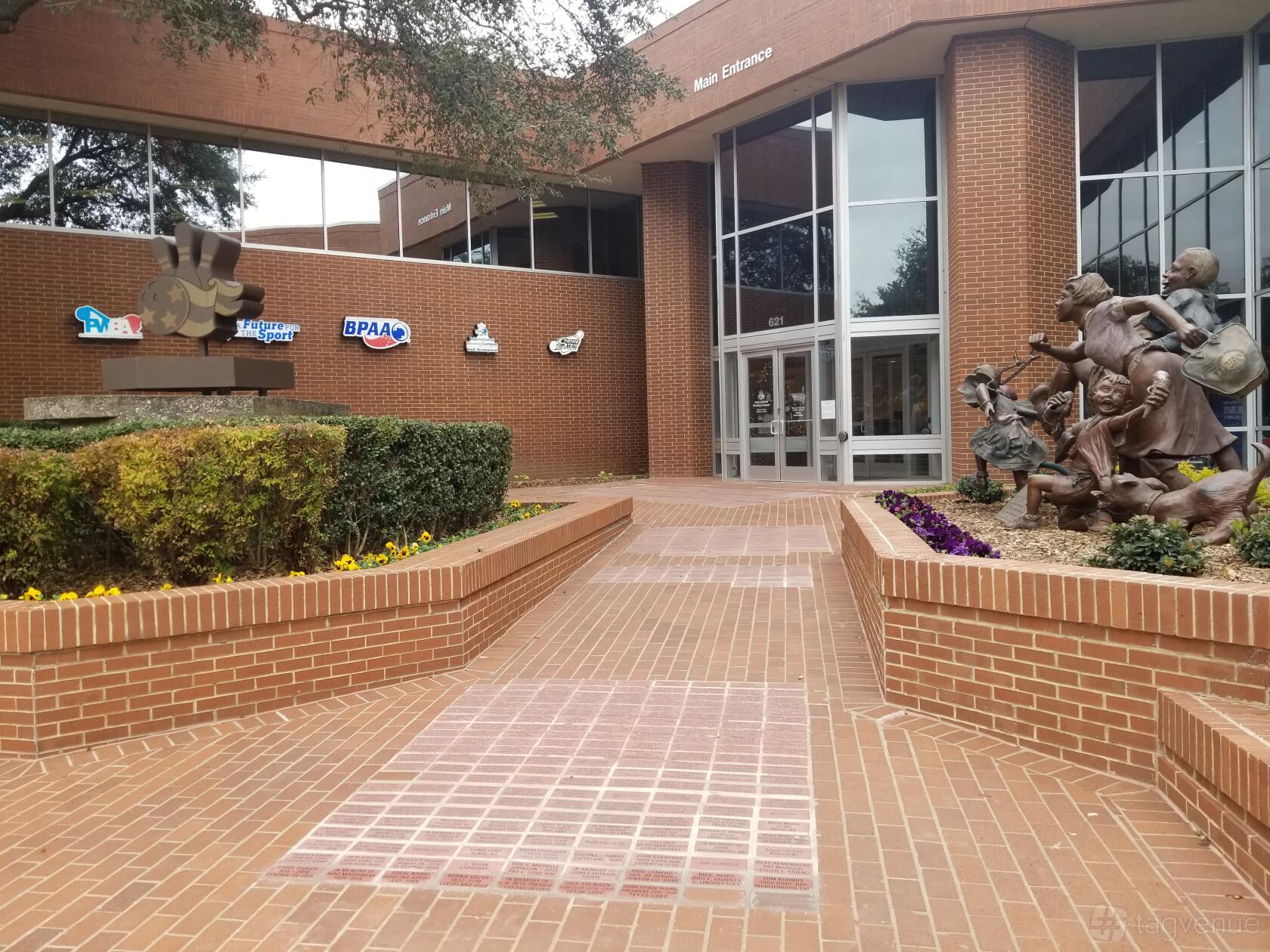 A museum entrance with large brick walkway and bronze bowling-themed sculptures at International Bowling Museum & Hall of Fame.