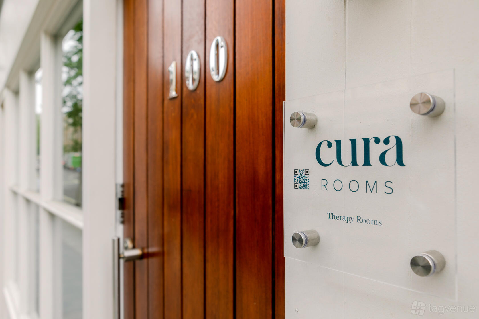 A coworking space with a wooden entry door and glass signage displaying CuraRooms Marylebone.