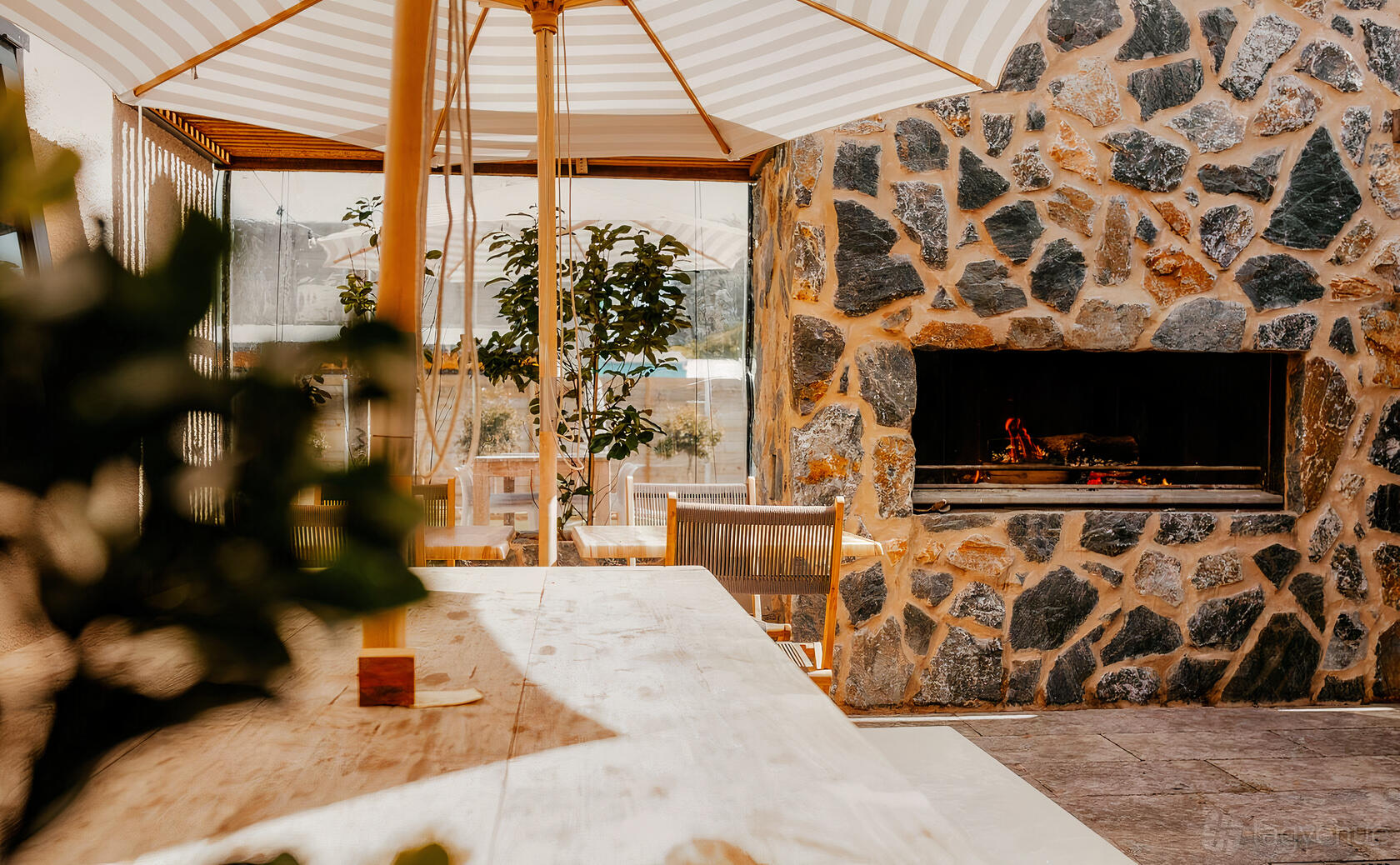 A function room with a stone fireplace, wooden table, and large umbrella at Oak and Anchor Hotel.