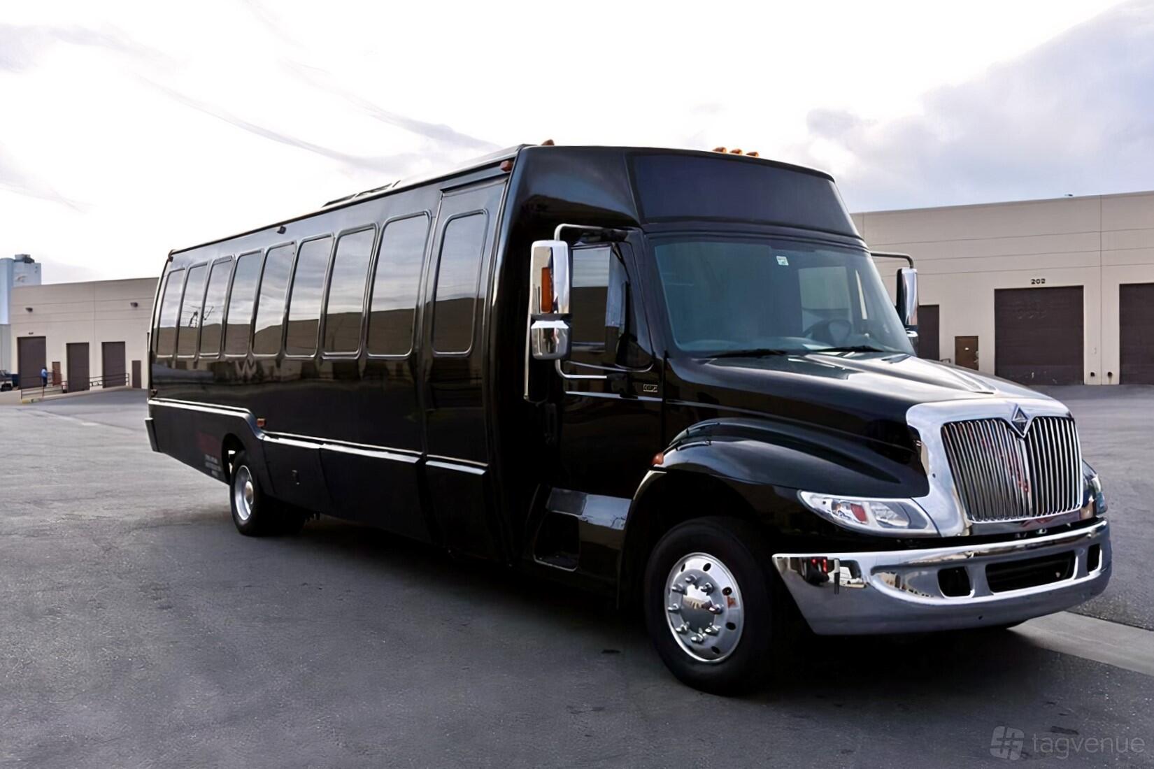 A large black party bus with tinted windows parked outside Sin City Club Crawl's The Black Pearl.