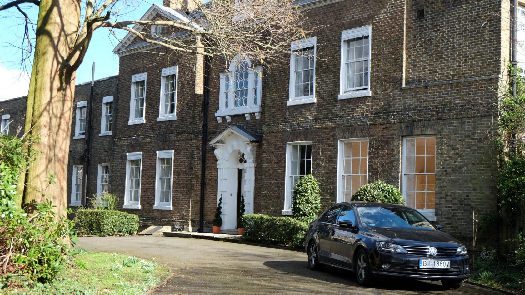 A country house with classic brick exterior, tall sash windows, and a white columned entrance at Bell House.