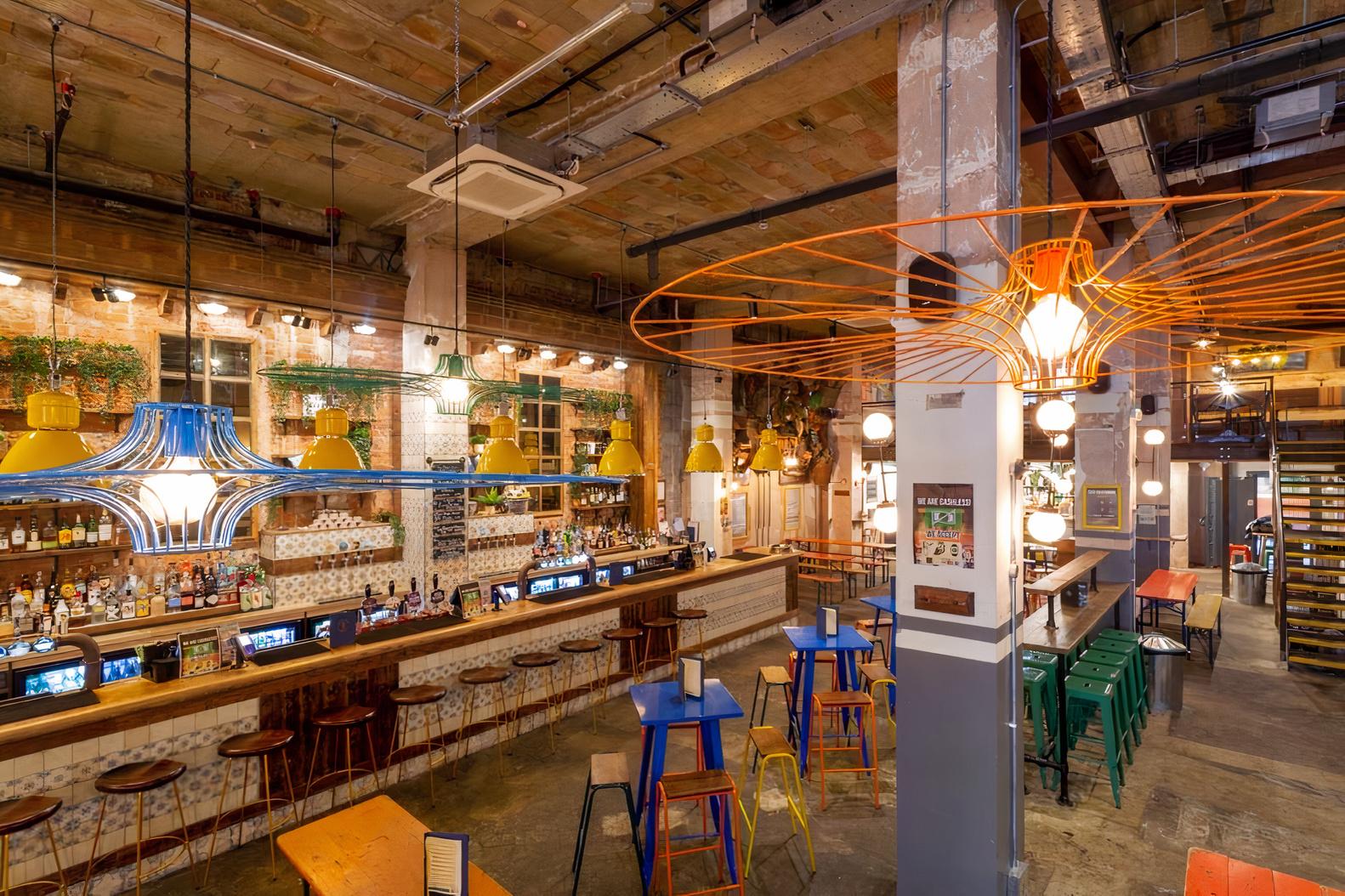 An event space in a hotel with exposed beams, eclectic seating, and a long bar at Market House.
