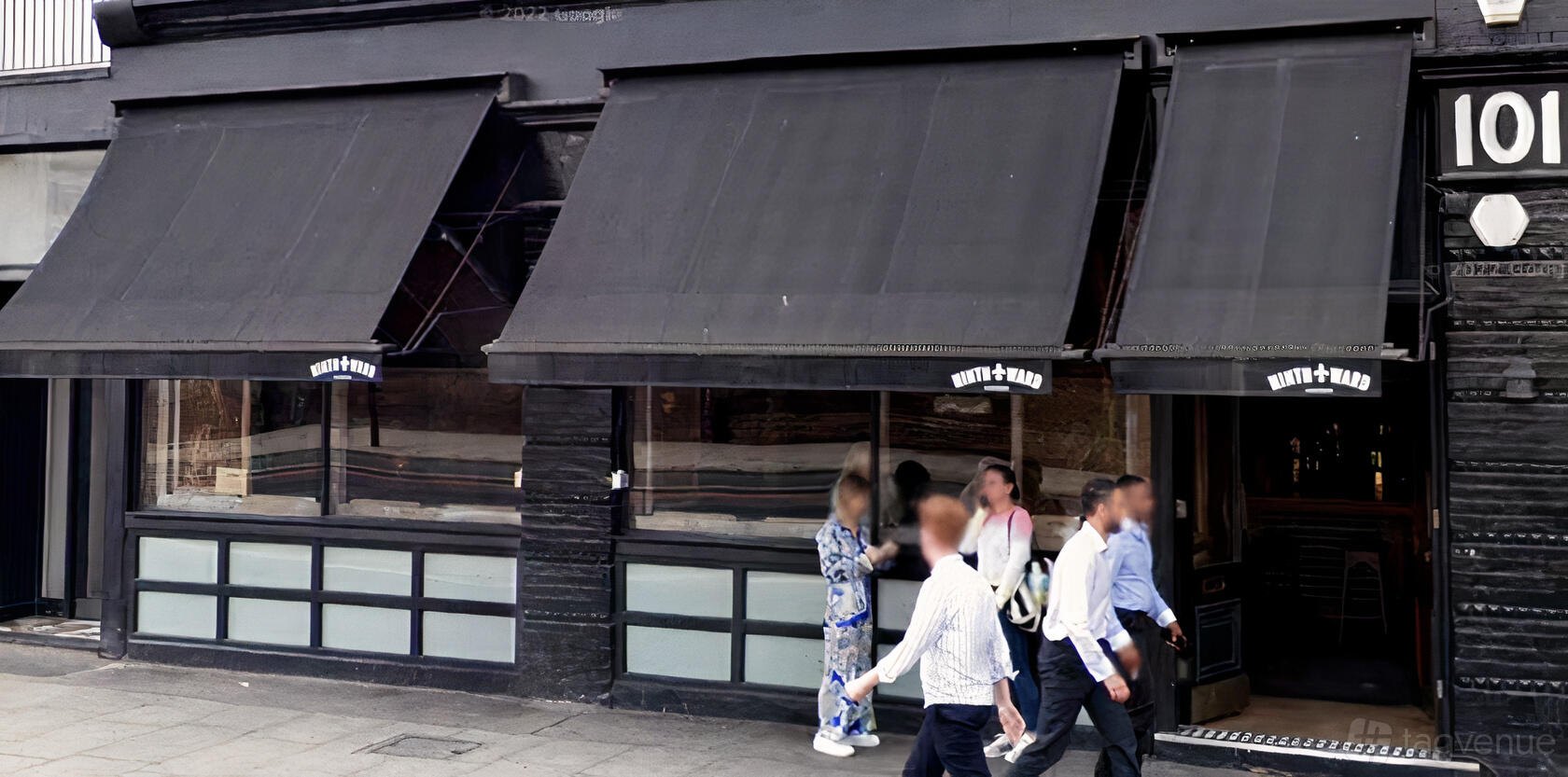 A restaurant facade with black awnings, large windows, and street-facing entrance at Ninth Ward London.