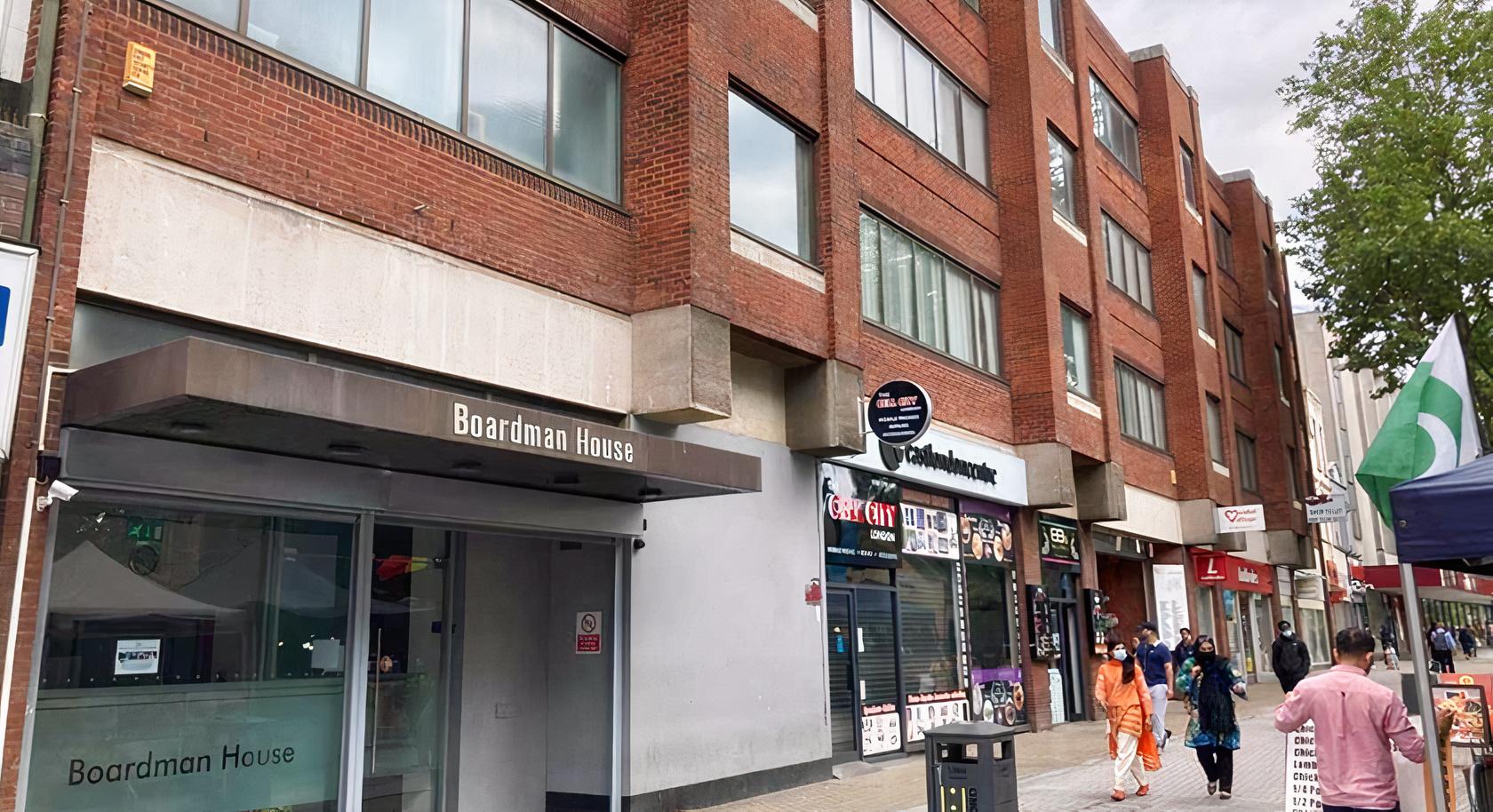 A conference centre with a red brick exterior and ground-level shops at Stratford