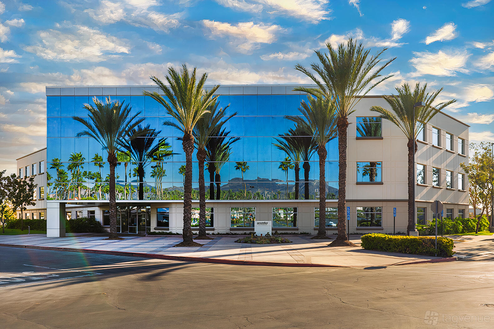 A coworking space with mirrored glass exterior and palm trees at Premier Workspaces - Foothill Ranch.