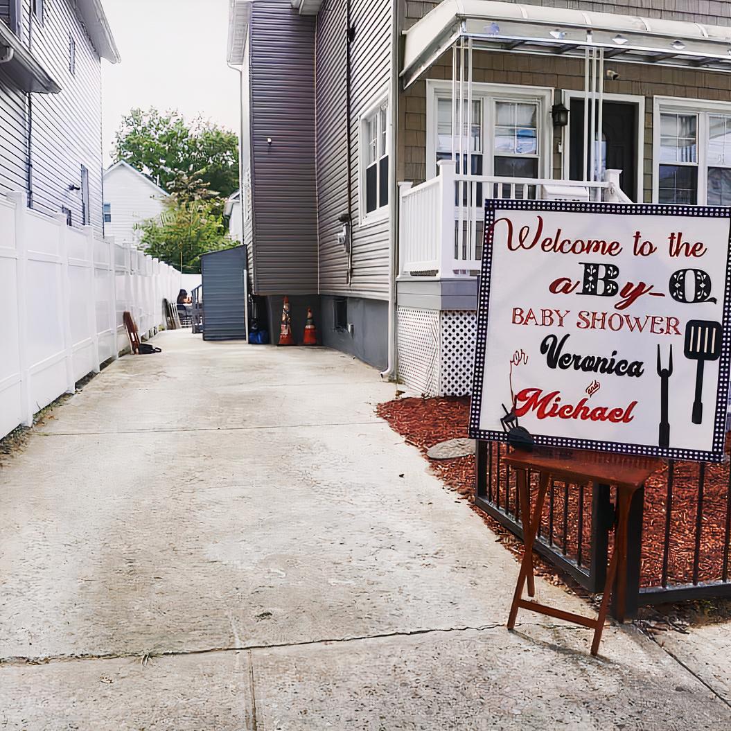 A versatile event space with a long paved outdoor walkway and a custom baby shower sign at The Graham Space.