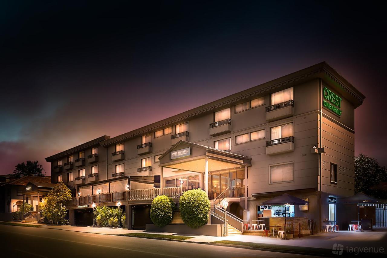 A multi-story event venue with balconies, illuminated signage, and exterior lighting at Crest On Barkly.