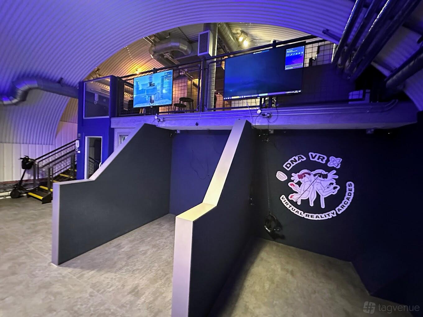 An event venue with VR gaming stations, wall monitors, and industrial arch ceilings at DNA VR Battersea Power Station.