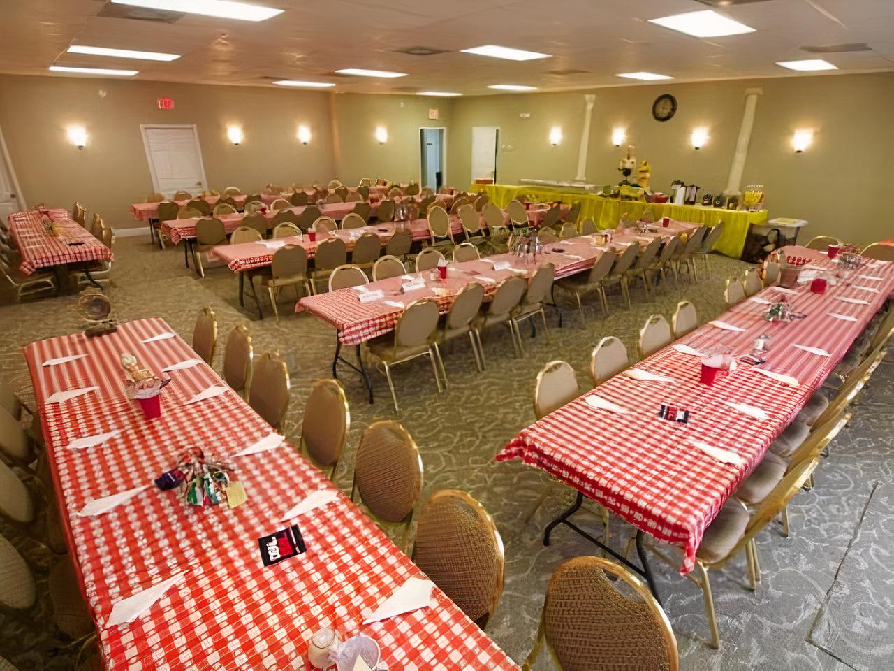 An event venue with rows of banquet tables covered in red and white checkered cloths at Fayette Event Center.