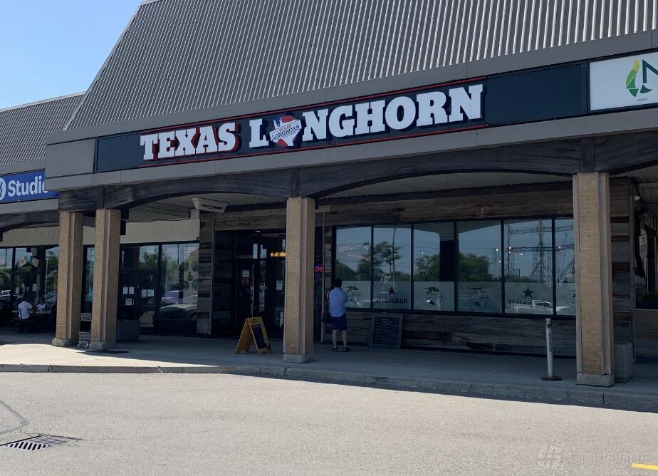 A restaurant with a wooden facade, large front windows, and TEXAS LONGHORN signage at TEXAS LONGHORN.