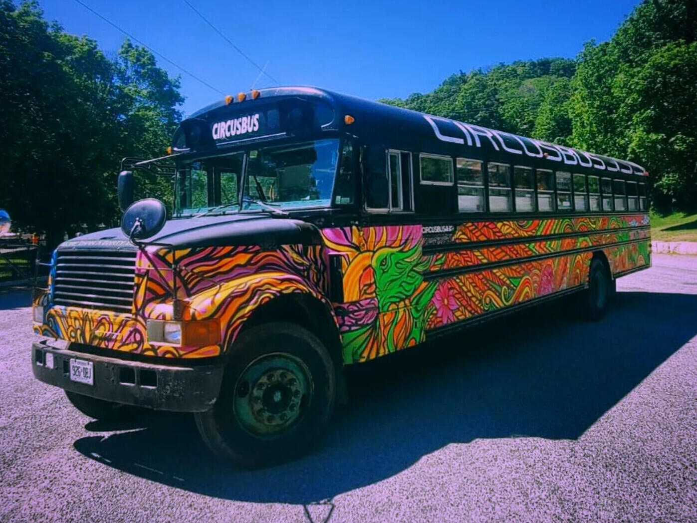 A party bus with colorful graffiti-style exterior artwork and large side windows at Circusbus Party Bus Toronto.