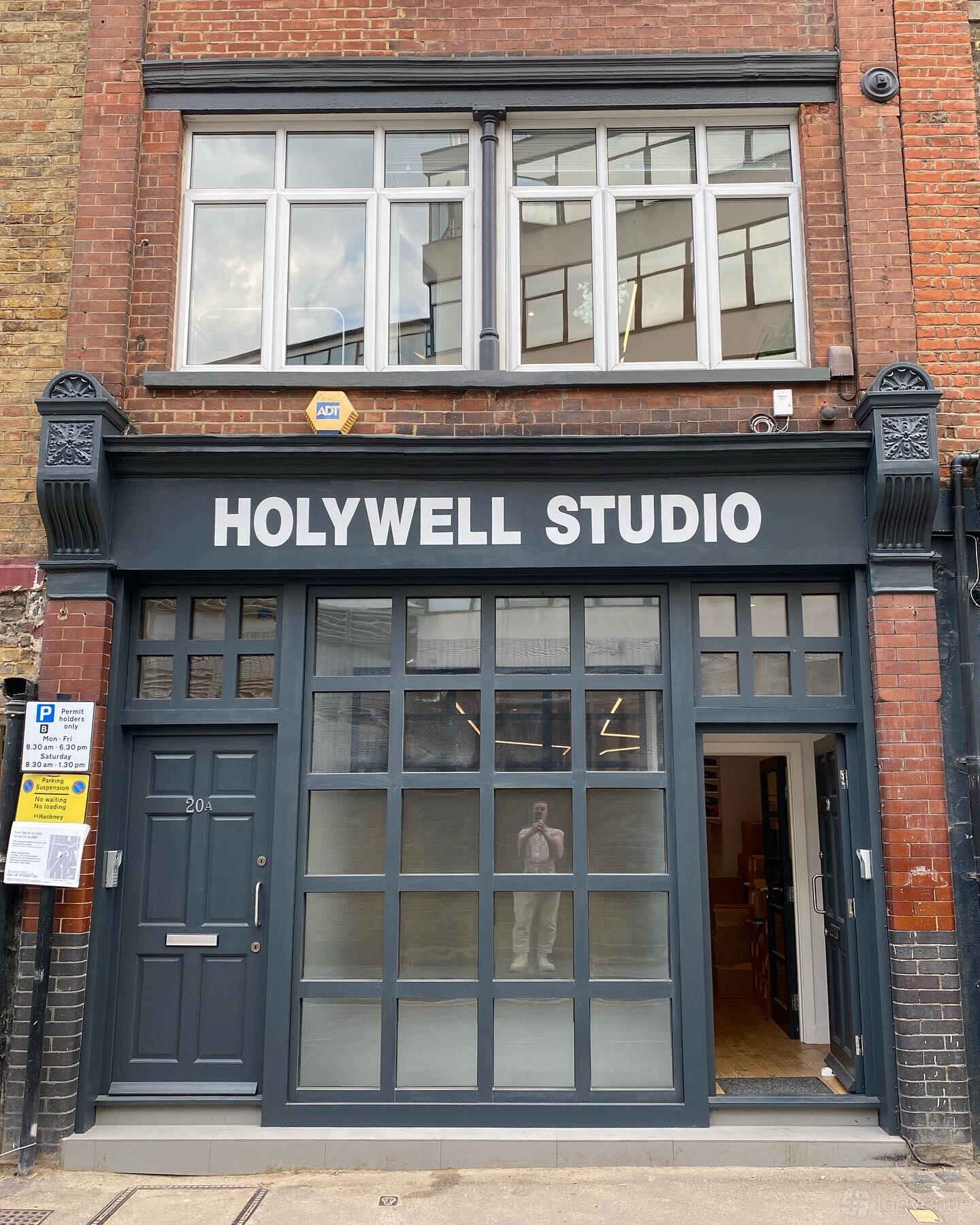 A recording studio with large industrial-style windows and a dark gray entrance at Holywell Studio.