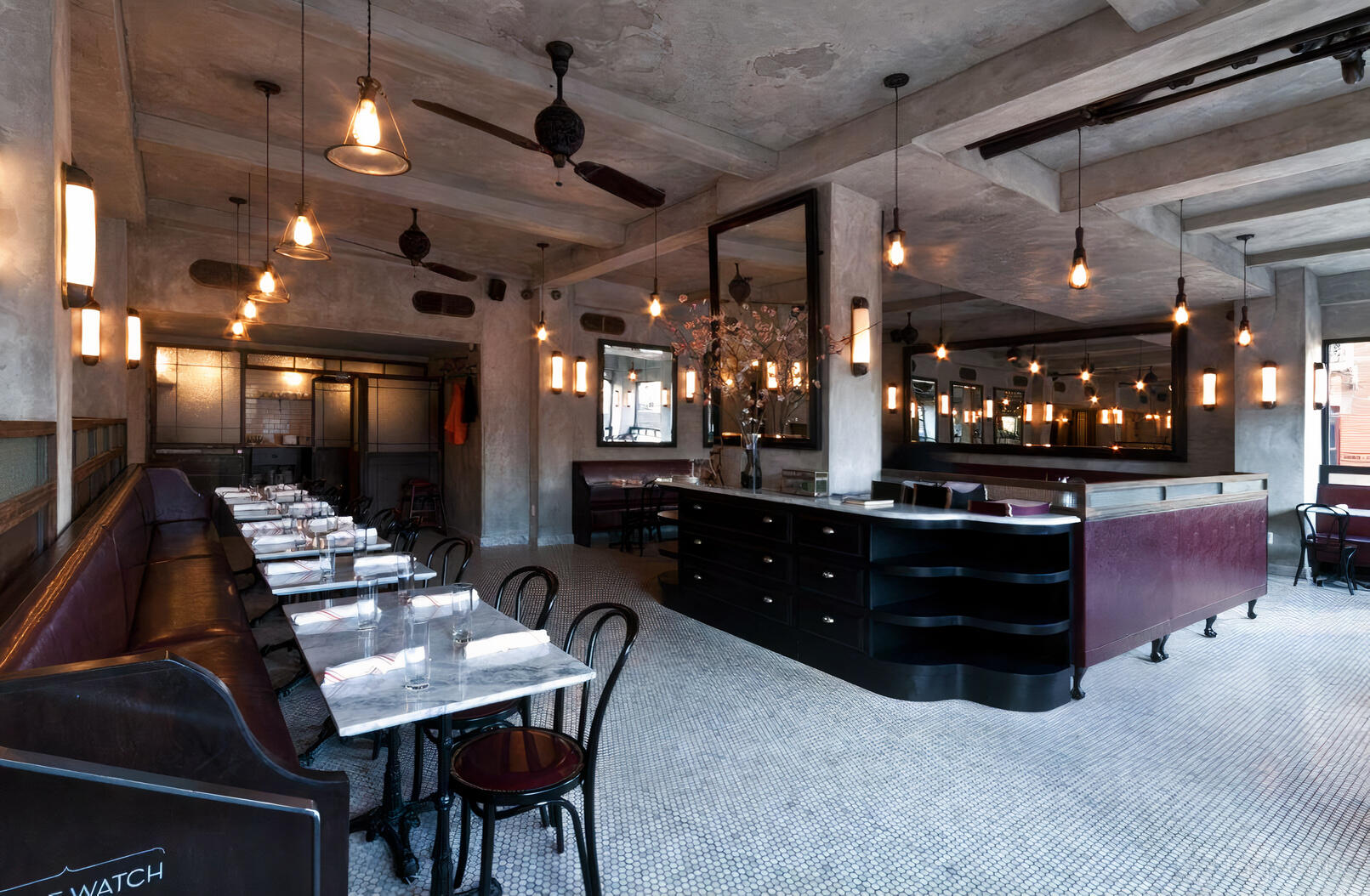 A restaurant with marble-topped tables, pendant lighting, and mosaic tile floors at Bevacco.
