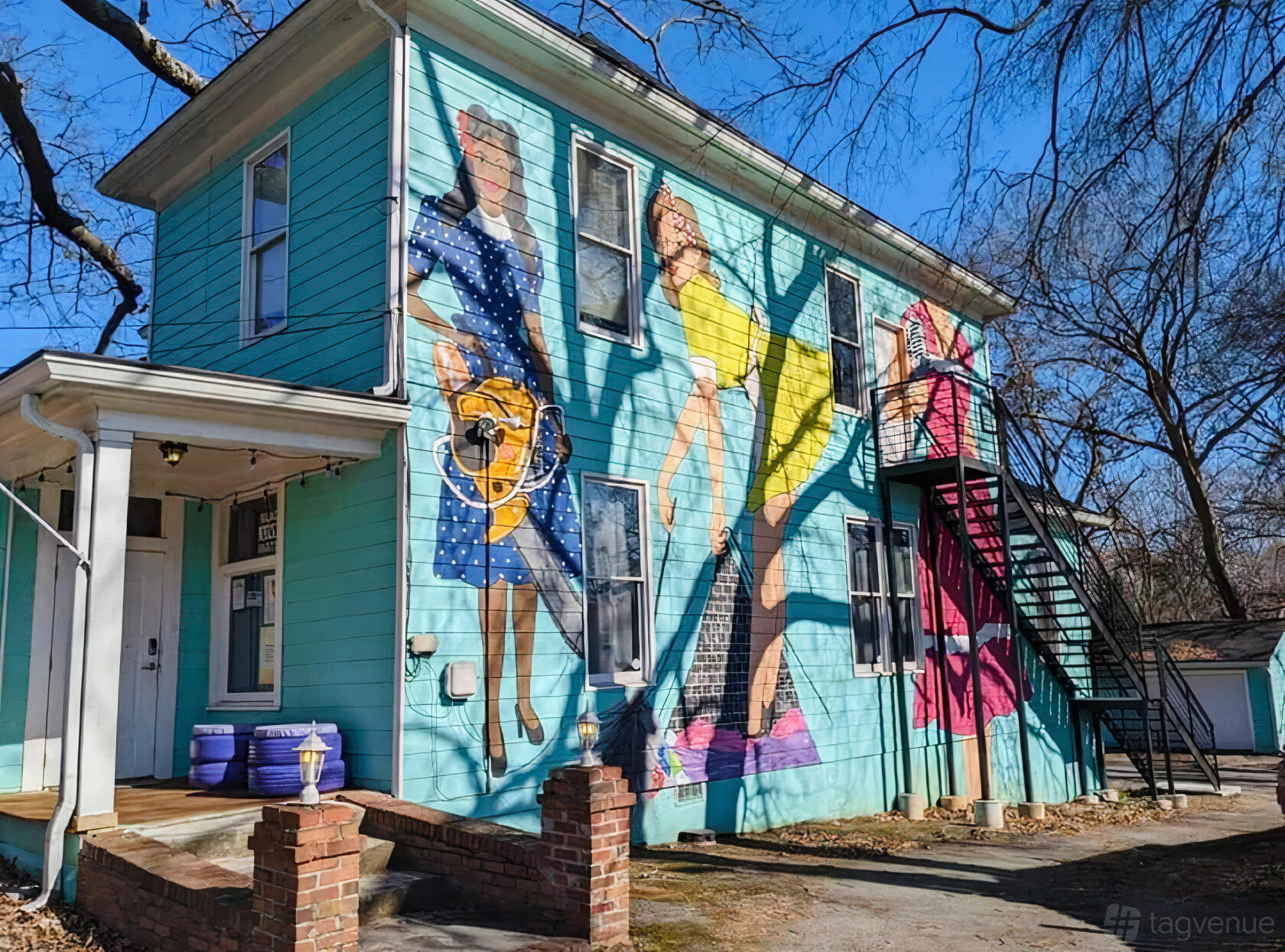 A dance studio with a turquoise exterior and vibrant mural of dancers on the side at Metropolitan Studios.