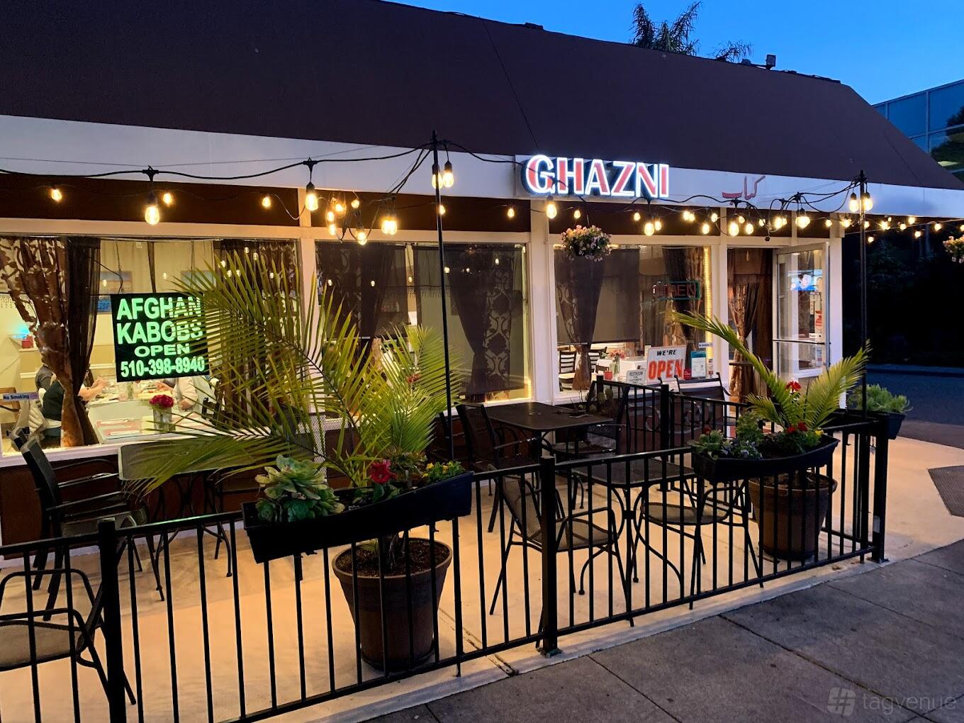 A terrace with outdoor seating, string lights, and potted plants at Ghazni Afghan Kabobs (Downtown Hayward).