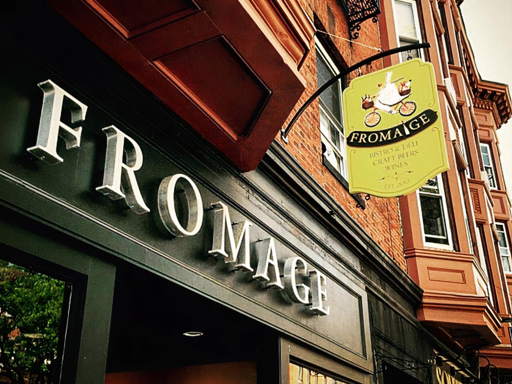 An exterior of a versatile event space with bold signage and a decorative hanging sign at Fromage Wine Bar & Restaurant.