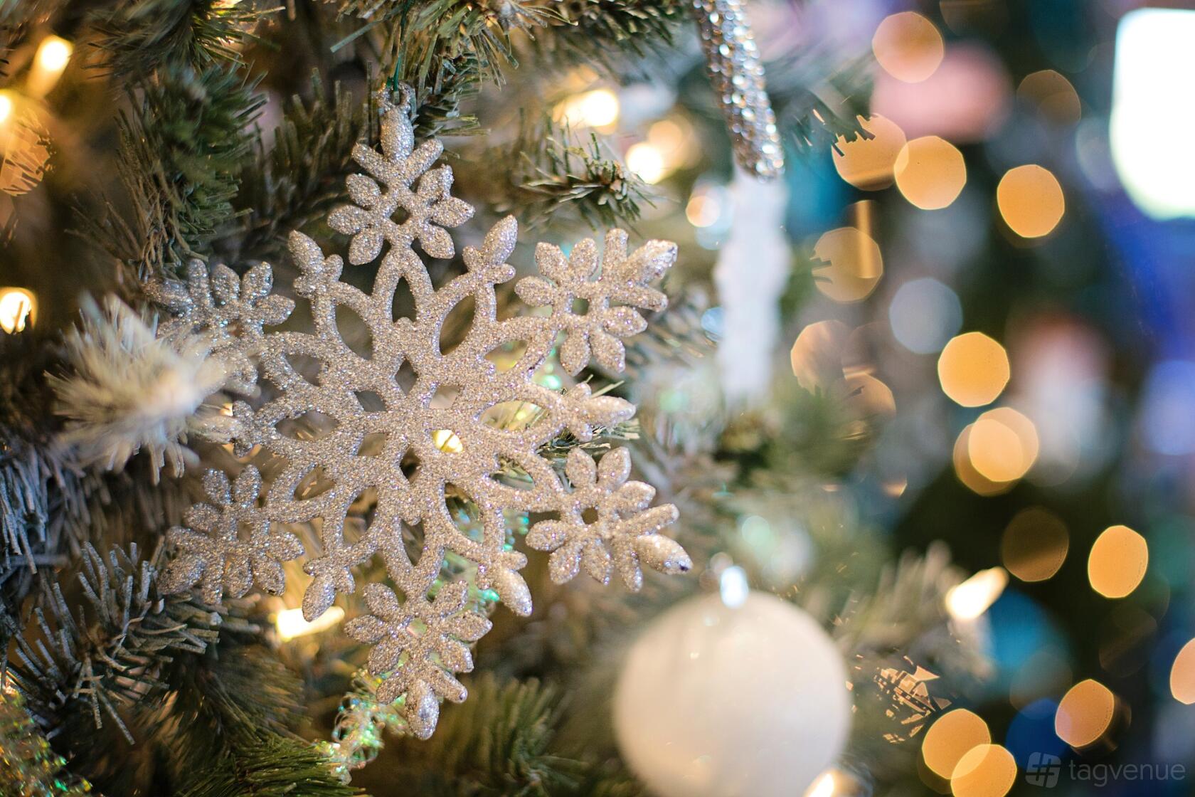 A dining room with a decorated Christmas tree featuring a glittery snowflake ornament at Flemings Mayfair Tyburn Suite.