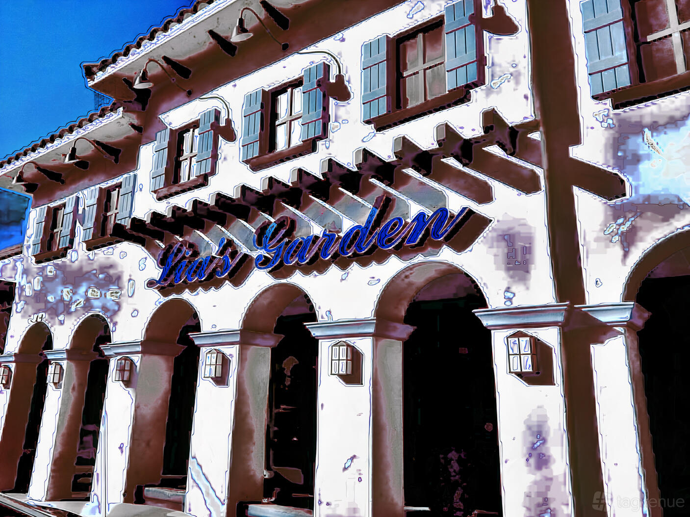 A banquet hall with stucco exterior walls, Spanish-style arched windows, and wooden shutters at Lia's Garden Banquet Hall.