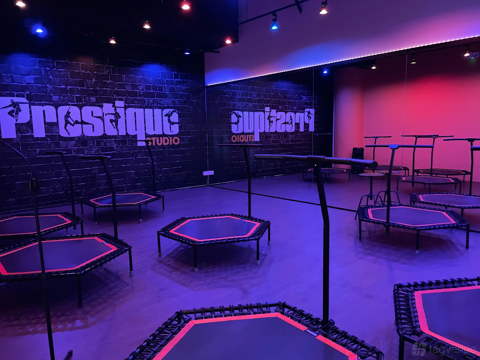 A fitness studio with mini trampolines, mirrored walls, and purple accent lighting at Prestique Studio (Marina Square).