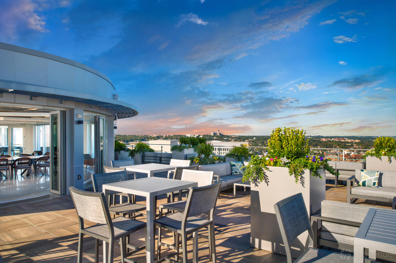 A restaurant rooftop with outdoor dining tables, potted greenery, and open sky views at Sfoglina Rosslyn.