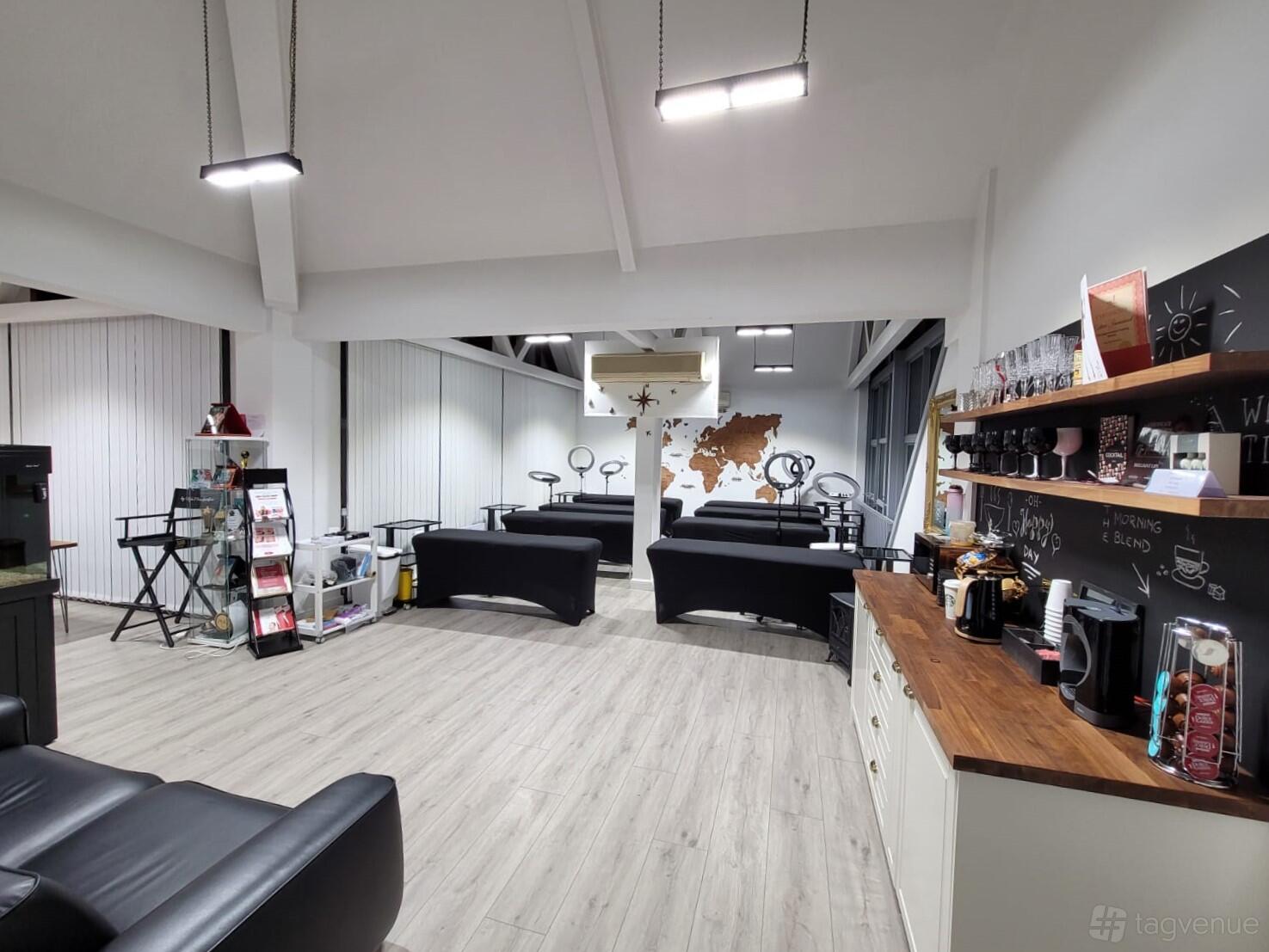 A training room with multiple workstations, a wall-mounted world map, and a coffee counter at Moda Donna PMU & Beauty Academy.