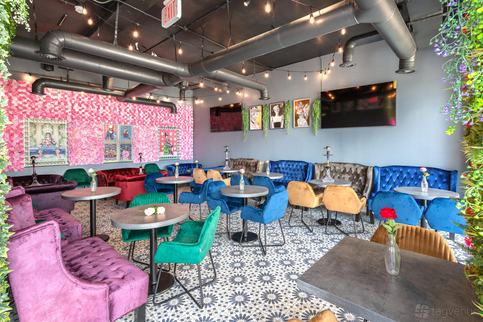A bar with velvet seating, patterned tile flooring, and floral accent walls at Le Jardin Hookah.