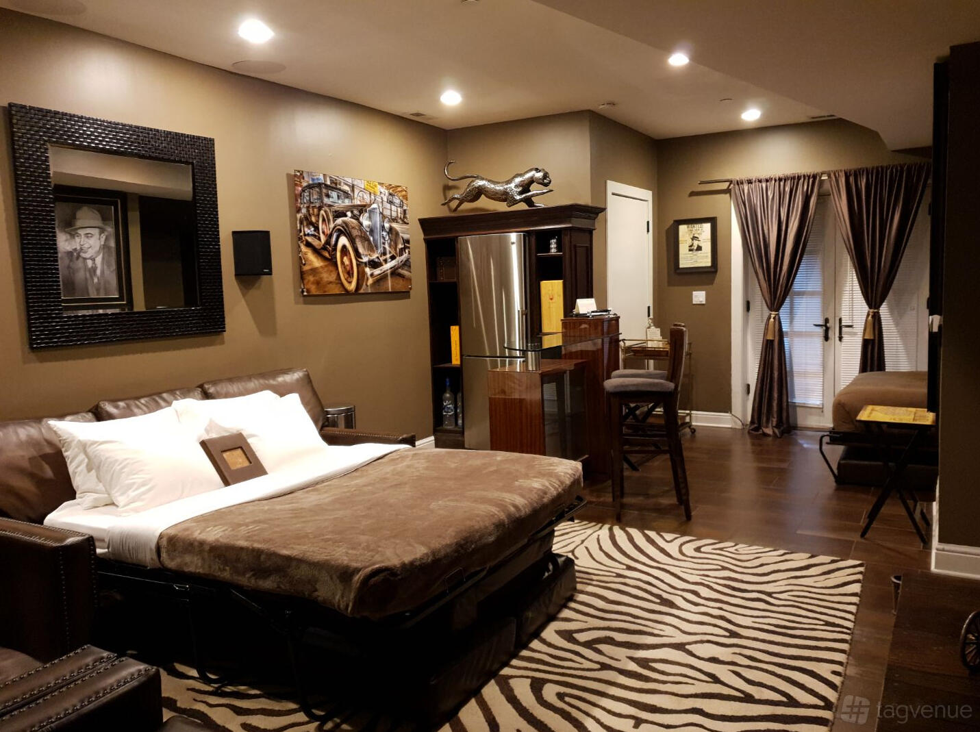 A house with a lounge area featuring a zebra rug, bar counter, and brown sleeper sofa at Villa D' Citta Bed & Breakfast.
